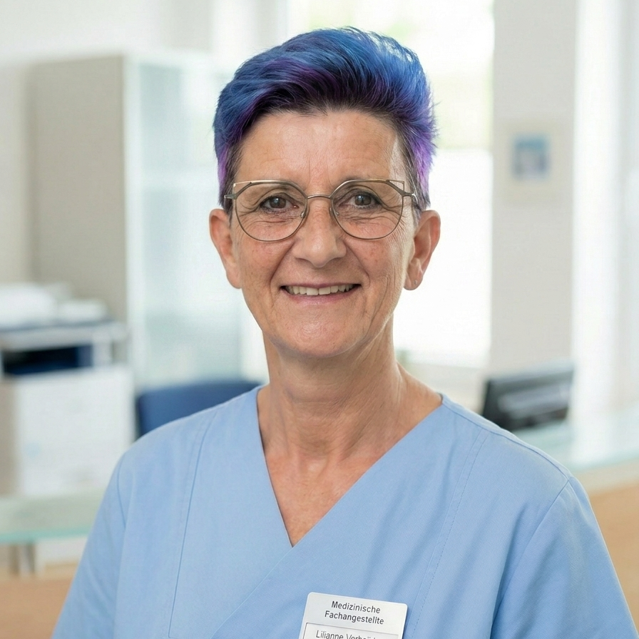 Lächelnde medizinische Fachkraft in blauer Uniform mit lila Haaren.